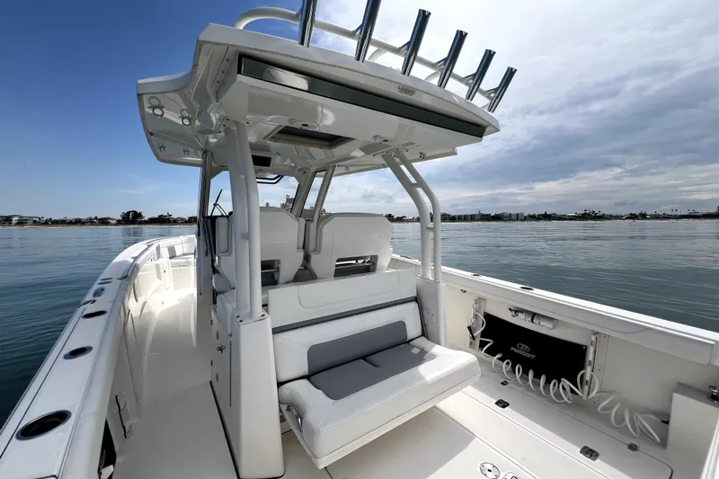 Slide: The Image of 2020 Pursuit S 328 Sport boat interior with seating, on calm water. - 13