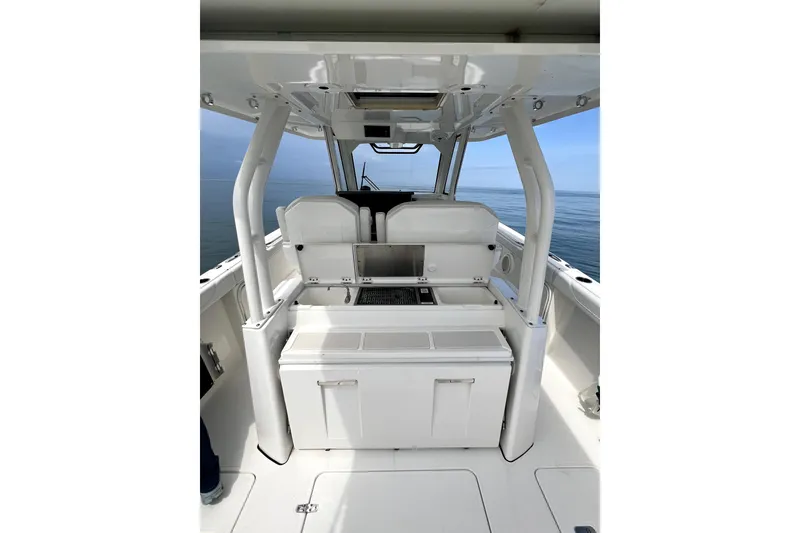 Slide: The Image of 2020 Pursuit S 328 Sport boat interior with seating and storage, on calm ocean waters. - 14
