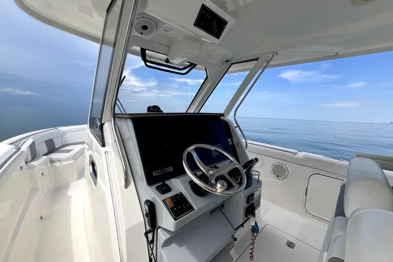 Slide: The Image of 2020 Pursuit S 328 Sport boat interior with steering wheel, ocean view. - 17