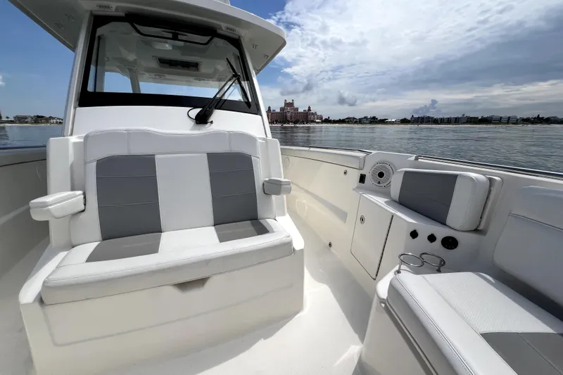 Slide: The Image of 2020 Pursuit S 328 Sport boat interior with seating, on calm water. - 24