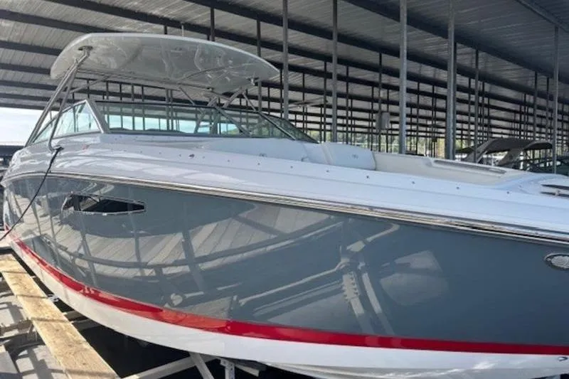 The Image of 2017 Cobalt R35 boat in covered storage, featuring sleek design and red accent stripe. - 0