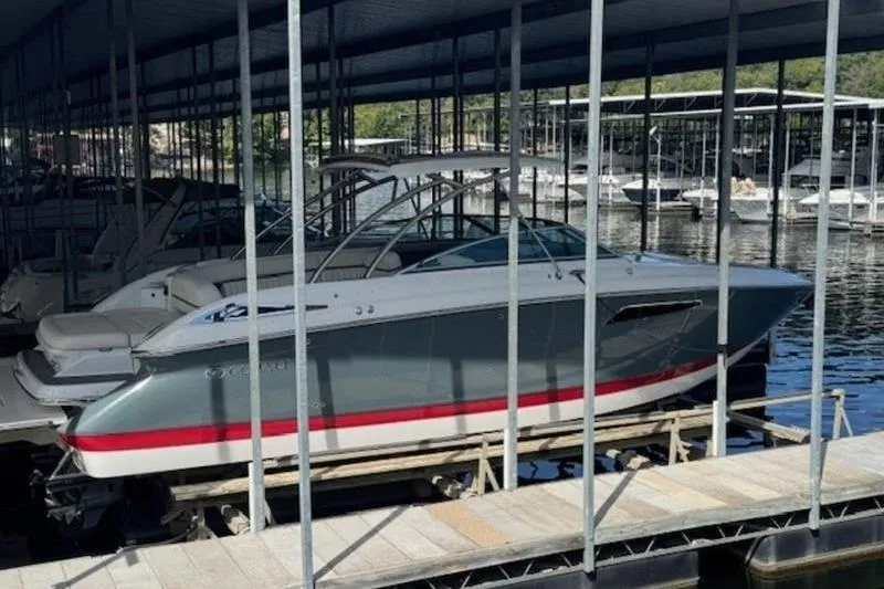 Slide: The Image of 2017 Cobalt R35 boat docked in a marina under a covered structure. - 2