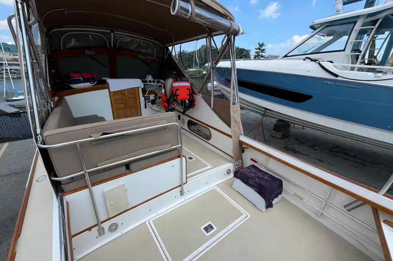 Slide: The Image of 2003 Dyer 29 Soft Top boat interior with seating and life jackets at a marina. - 18
