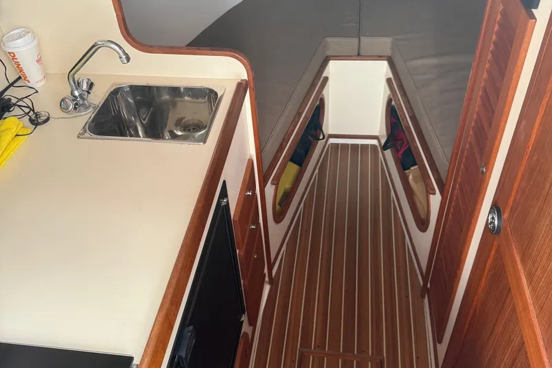 Slide: The Image of Interior of a 2003 Dyer 29 Soft Top boat with sink and wooden flooring. - 19