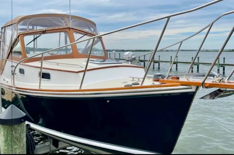 Slide: The Image of 2003 Dyer 29 Soft Top boat docked by the water on a clear day. - 2