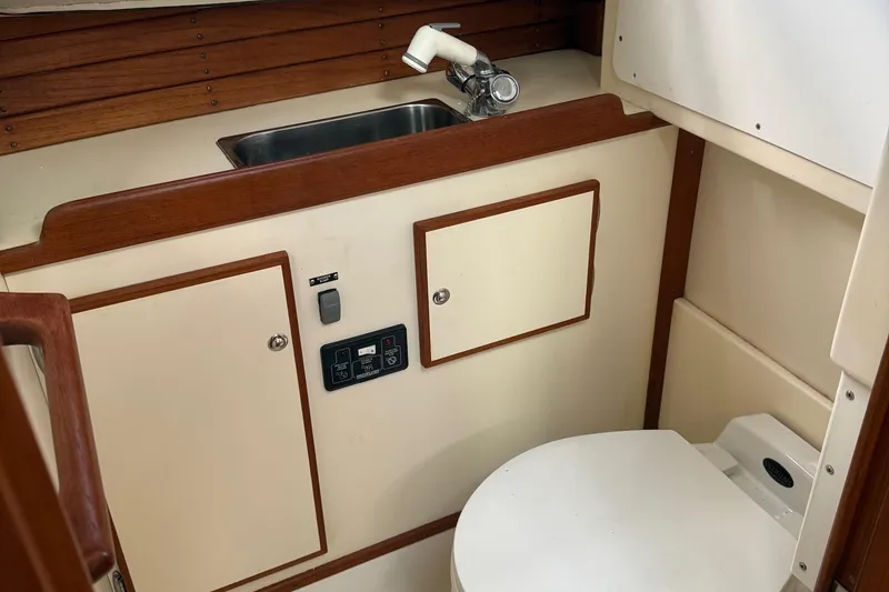 Slide: The Image of 2003 Dyer 29 Soft Top boat interior with sink and toilet, featuring wood accents. - 20