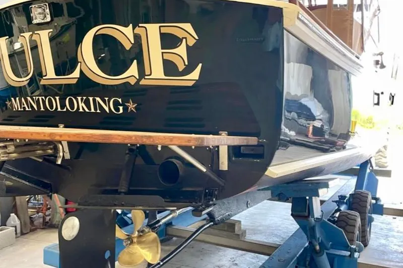 Slide: The Image of 2003 Dyer 29 Soft Top boat on lift, showcasing propeller and hull details. - 29