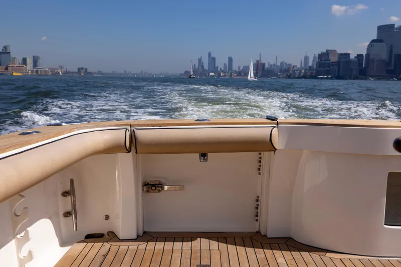 Slide: The Image of Luxurious 2012 Cabo 44 Hardtop Express yacht with elegant wooden deck and fishing rod holders. - 101