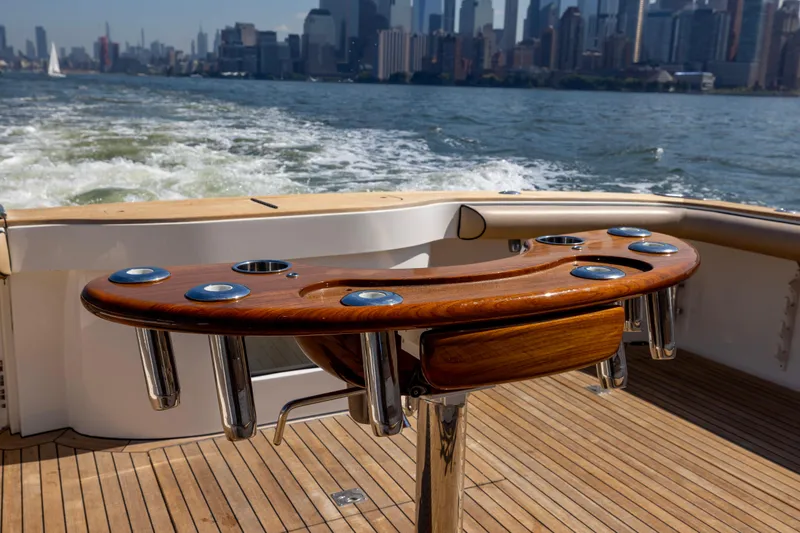 Slide: The Image of 2012 Cabo 44 Hardtop Express yacht cruising with city skyline view. - 103