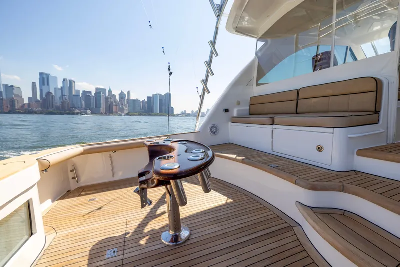 Slide: The Image of Luxurious 2012 Cabo 44 Hardtop Express yacht with city skyline view, featuring elegant deck seating. - 105