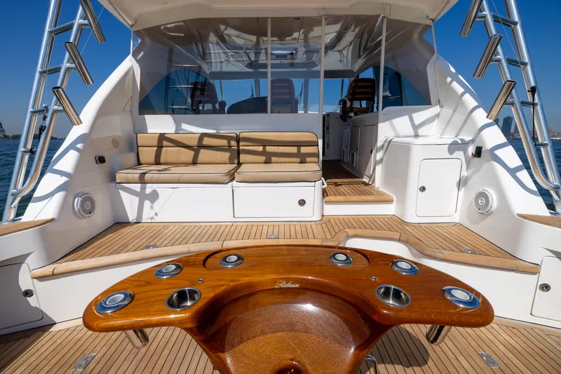 Slide: The Image of 2012 Cabo 44 Hardtop Express yacht with city skyline view, featuring spacious deck and seating. - 106