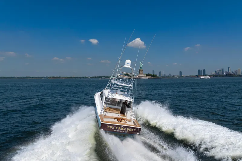 Slide: The Image of 2012 Cabo 44 Hardtop Express cruising near the Statue of Liberty on a sunny day. - 11
