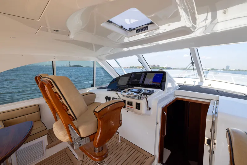 Slide: The Image of 2012 Cabo 44 Hardtop Express yacht helm with luxurious seating and advanced navigation system. - 118