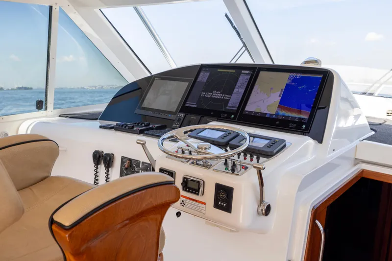 Slide: The Image of 2012 Cabo 44 Hardtop Express yacht interior with helm, luxurious seating, and ocean view. - 119