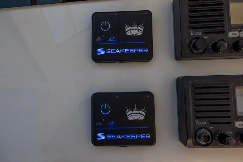 Slide: The Image of Seakeeper and VHF marine radio controls on 2012 Cabo 44 Hardtop Express boat. - 121