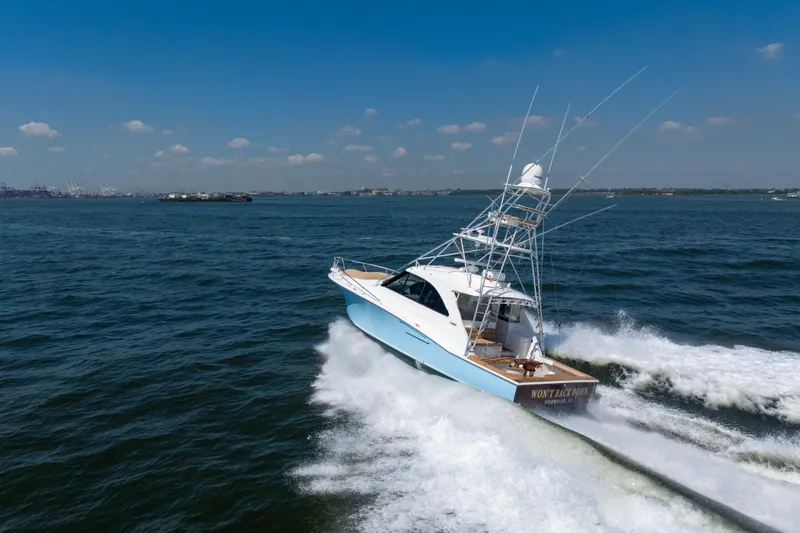 Slide: The Image of 2012 Cabo 44 Hardtop Express yacht cruising on open water under clear skies. - 13