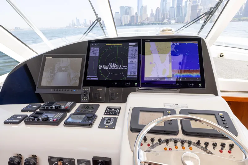 Slide: The Image of Control panel of 2012 Cabo 44 Hardtop Express yacht with city skyline view. - 134