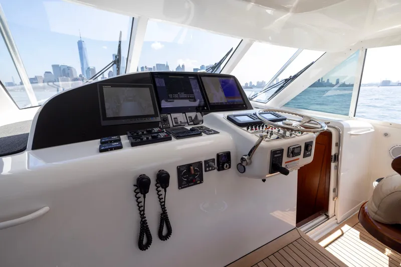 Slide: The Image of Helm of 2012 Cabo 44 Hardtop Express with advanced navigation systems and city skyline view. - 136