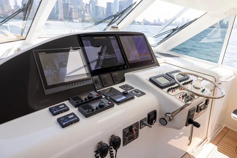 Slide: The Image of Helm of 2012 Cabo 44 Hardtop Express yacht with city skyline view. - 137