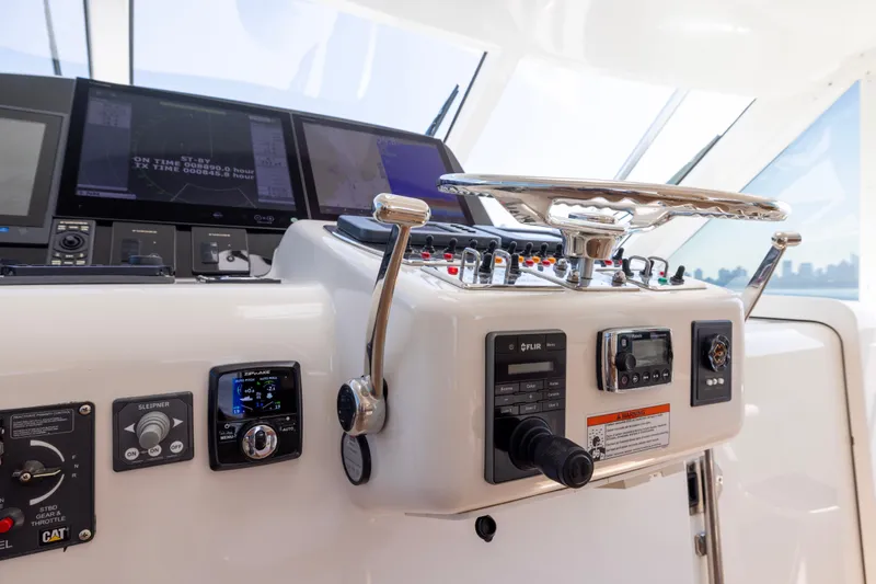 Slide: The Image of Control panel of 2012 Cabo 44 Hardtop Express yacht with steering wheel and navigation equipment. - 141