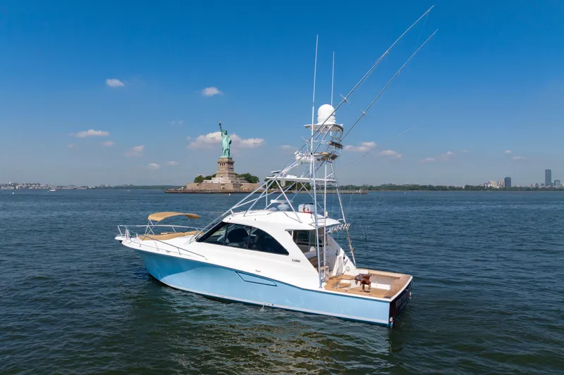 Slide: The Image of 2012 Cabo 44 Hardtop Express yacht near Statue of Liberty on sunny day. - 143