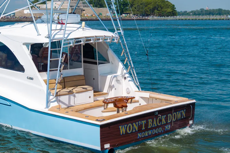 Slide: The Image of 2012 Cabo 44 Hardtop Express yacht cruising on a sunny day, featuring a spacious deck. - 146