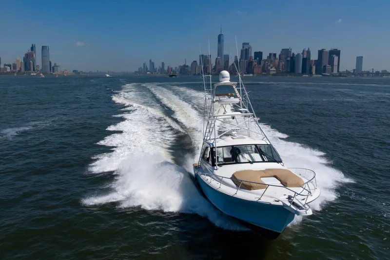 Slide: The Image of 2012 Cabo 44 Hardtop Express cruising near city skyline on a sunny day. - 15