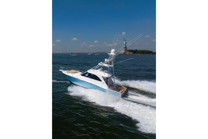 Slide: The Image of 2012 Cabo 44 Hardtop Express yacht cruising near the Statue of Liberty. - 18