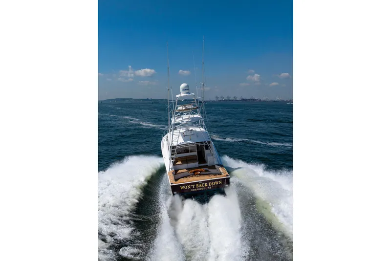 Slide: The Image of 2012 Cabo 44 Hardtop Express yacht cruising on open water, leaving a wake behind. - 19