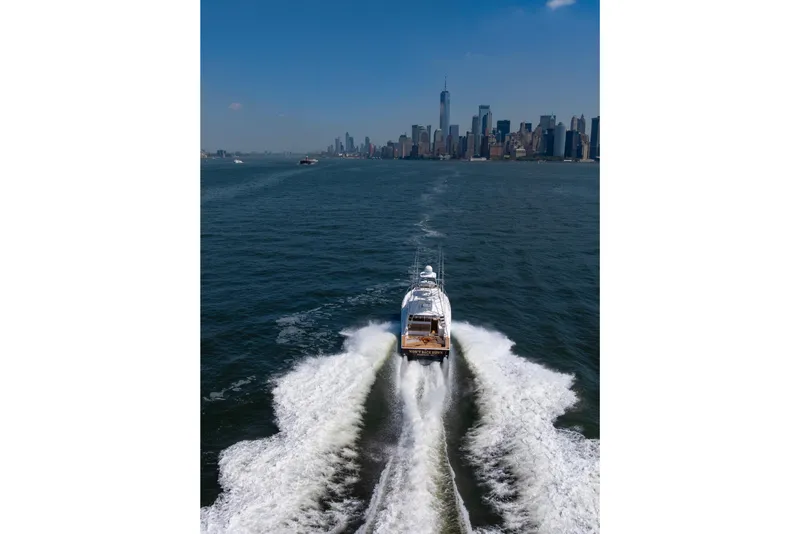 Slide: The Image of Cabo 44 Hardtop Express 2012 cruising near city skyline on a sunny day. - 22