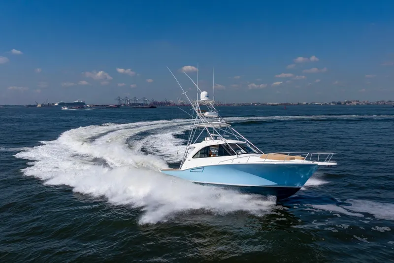 Slide: The Image of 2012 Cabo 44 Hardtop Express yacht cruising on open water under clear skies. - 28