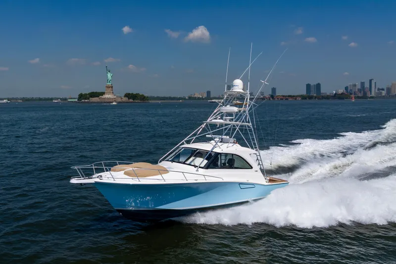 Slide: The Image of 2012 Cabo 44 Hardtop Express cruising near the Statue of Liberty on a sunny day. - 31