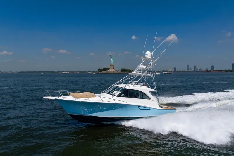 Slide: The Image of 2012 Cabo 44 Hardtop Express yacht cruising near the Statue of Liberty. - 32