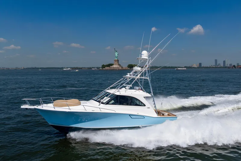Slide: The Image of 2012 Cabo 44 Hardtop Express yacht cruising near Statue of Liberty on sunny day. - 33