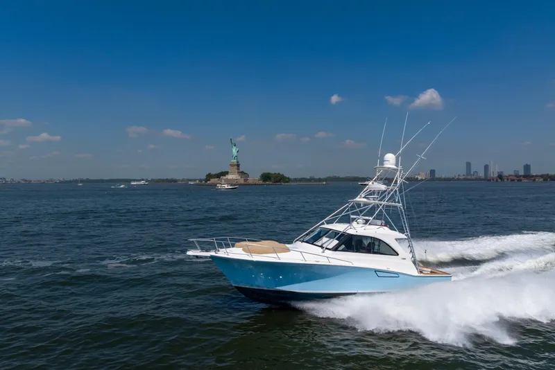 Slide: The Image of Cabo 44 Hardtop Express 2012 cruising near Statue of Liberty on a sunny day. - 34