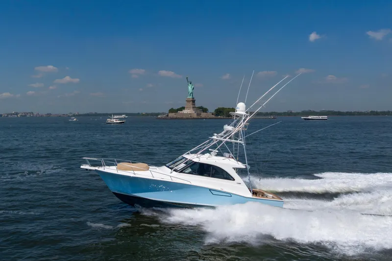 Slide: The Image of 2012 Cabo 44 Hardtop Express yacht cruising near the Statue of Liberty. - 35