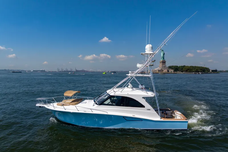 Slide: The Image of 2012 Cabo 44 Hardtop Express yacht cruising near the Statue of Liberty. - 45