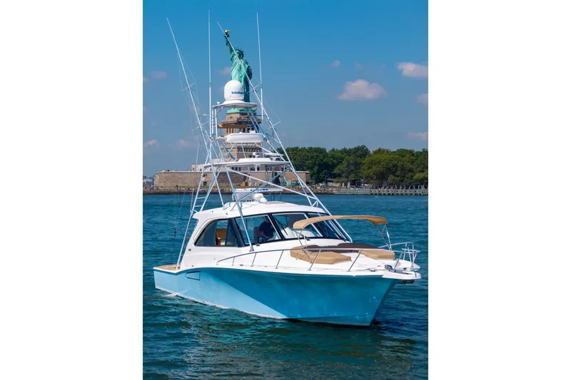 Slide: The Image of 2012 Cabo 44 Hardtop Express yacht cruising near the Statue of Liberty. - 46