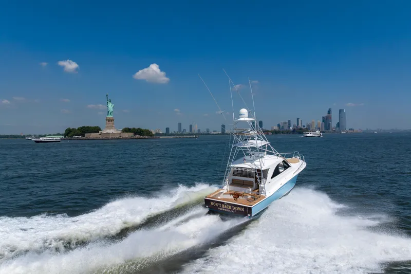 Slide: The Image of Cabo 44 Hardtop Express 2012 cruising near Statue of Liberty, New York City skyline in background. - 5