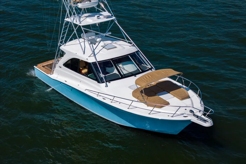 Slide: The Image of 2012 Cabo 44 Hardtop Express yacht cruising on open water. - 52