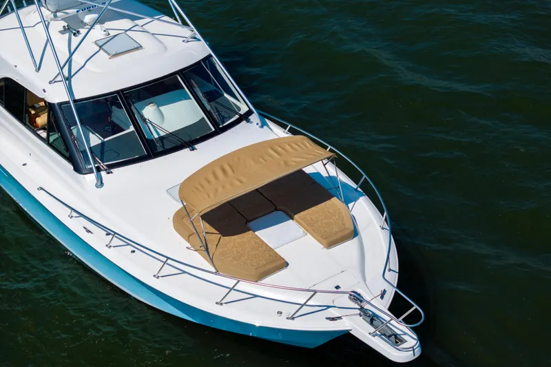 Slide: The Image of 2012 Cabo 44 Hardtop Express yacht with sunbathing area on calm water. - 53