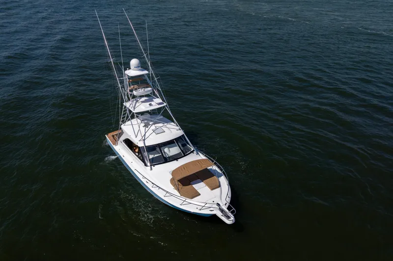 Slide: The Image of 2012 Cabo 44 Hardtop Express yacht cruising on open water. - 54