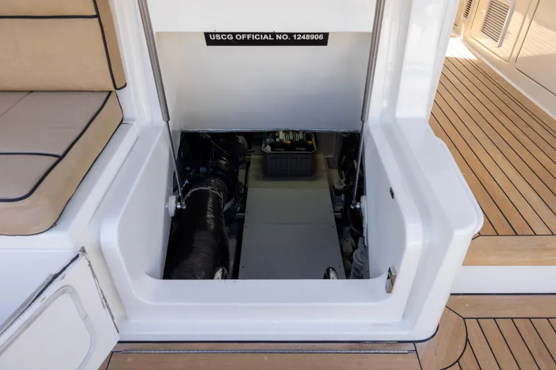 Slide: The Image of 2012 Cabo 44 Hardtop Express engine compartment with teak flooring and cushioned seating. - 69