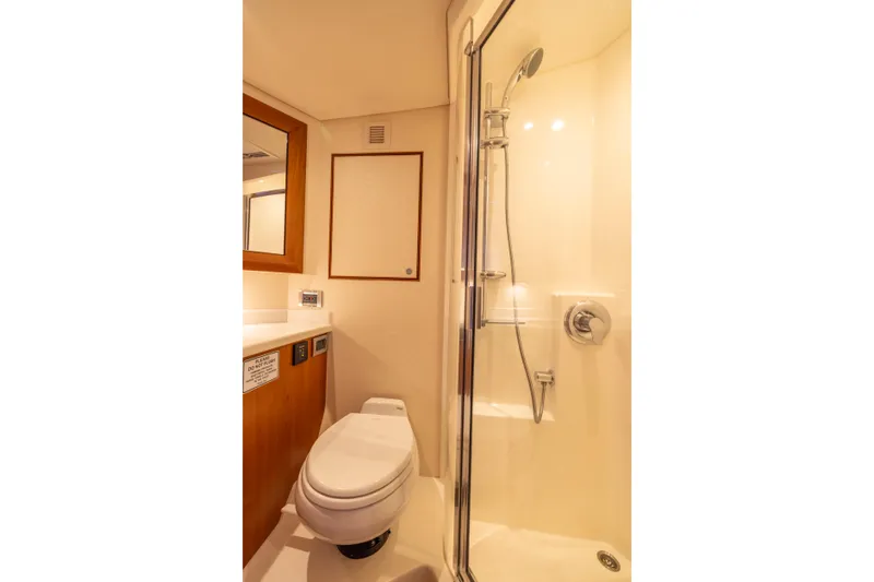 Slide: The Image of Luxurious bathroom in 2012 Cabo 44 Hardtop Express yacht with shower and wooden cabinetry. - 78