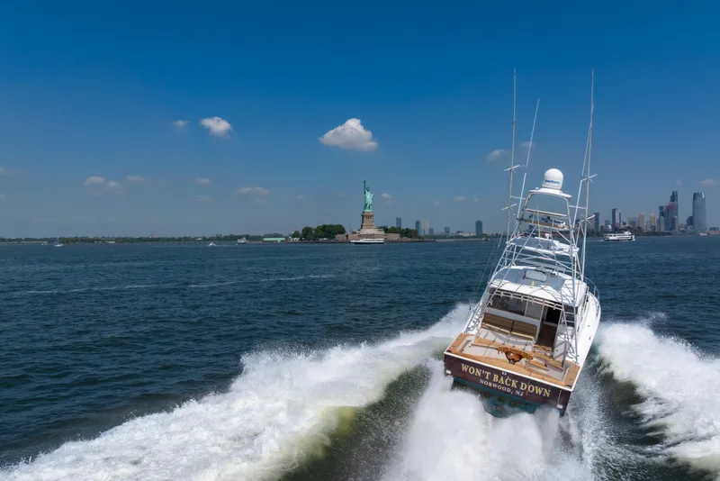Slide: The Image of 2012 Cabo 44 Hardtop Express cruising near Statue of Liberty on a sunny day. - 8