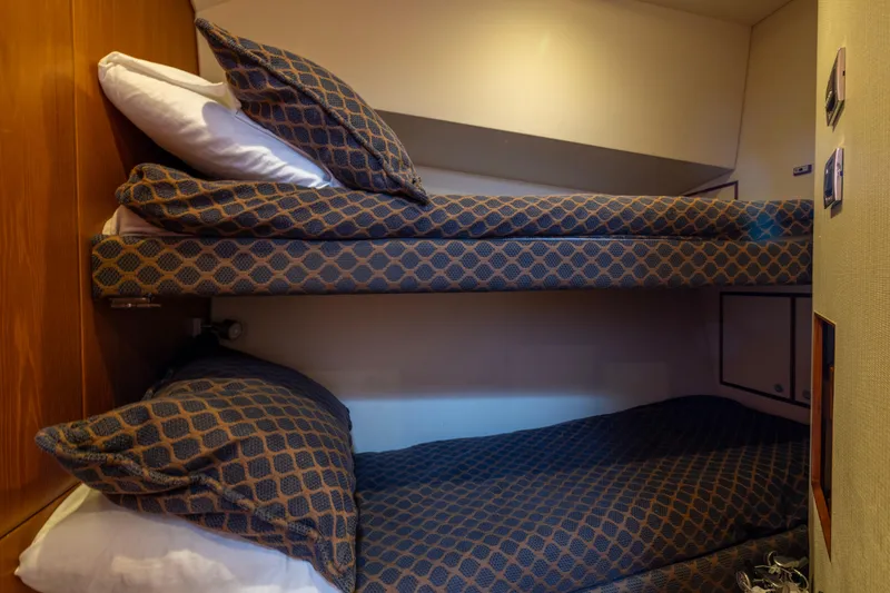 Slide: The Image of Interior of 2012 Cabo 44 Hardtop Express with bunk beds and wooden stairs. - 86