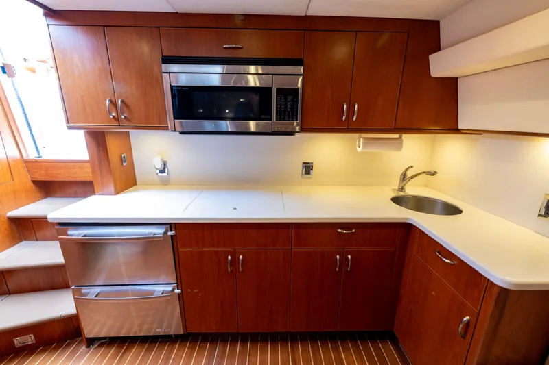 Slide: The Image of Luxurious 2012 Cabo 44 Hardtop Express yacht kitchen with wood cabinetry and stainless steel appliances. - 89