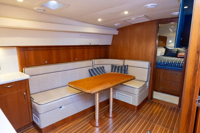 Slide: The Image of Interior of 2012 Cabo 44 Hardtop Express yacht with wooden dining area and seating. - 96