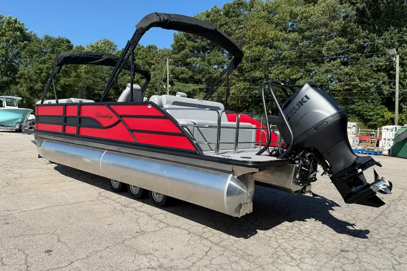 Slide: The Image of 2025 Bentley Pontoons Legacy 243 Swingback with Suzuki outboard motor, parked outdoors. - 3