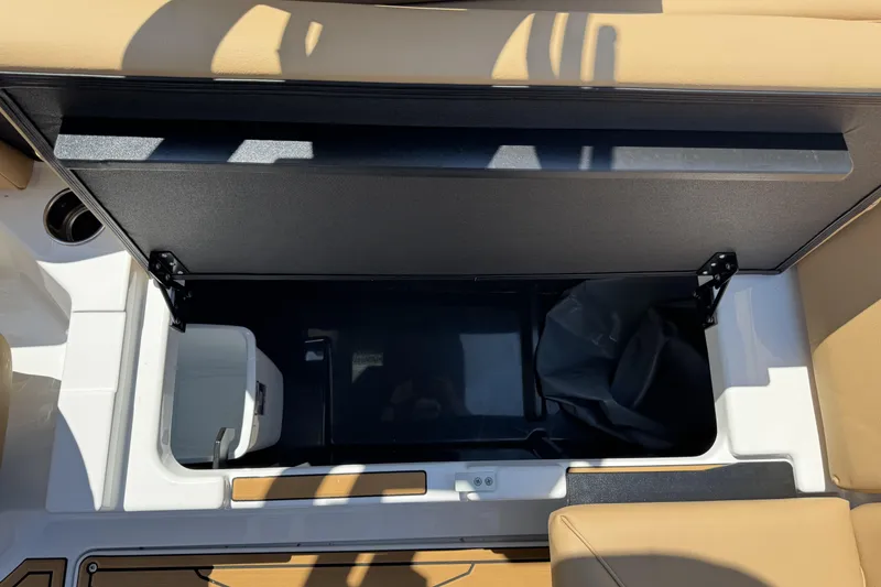 Slide: The Image of 2026 ATX Surf Boats 22 Type-S storage compartment with tan seating and black interior. - 13